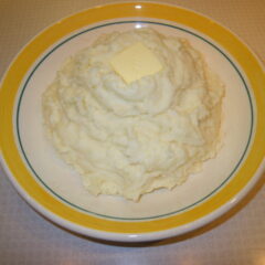 Garlic mashed potatoes in a bowl and topped by a square of butter